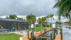 A pool area with a covered seating area, a wooden deck, and a water lock system.