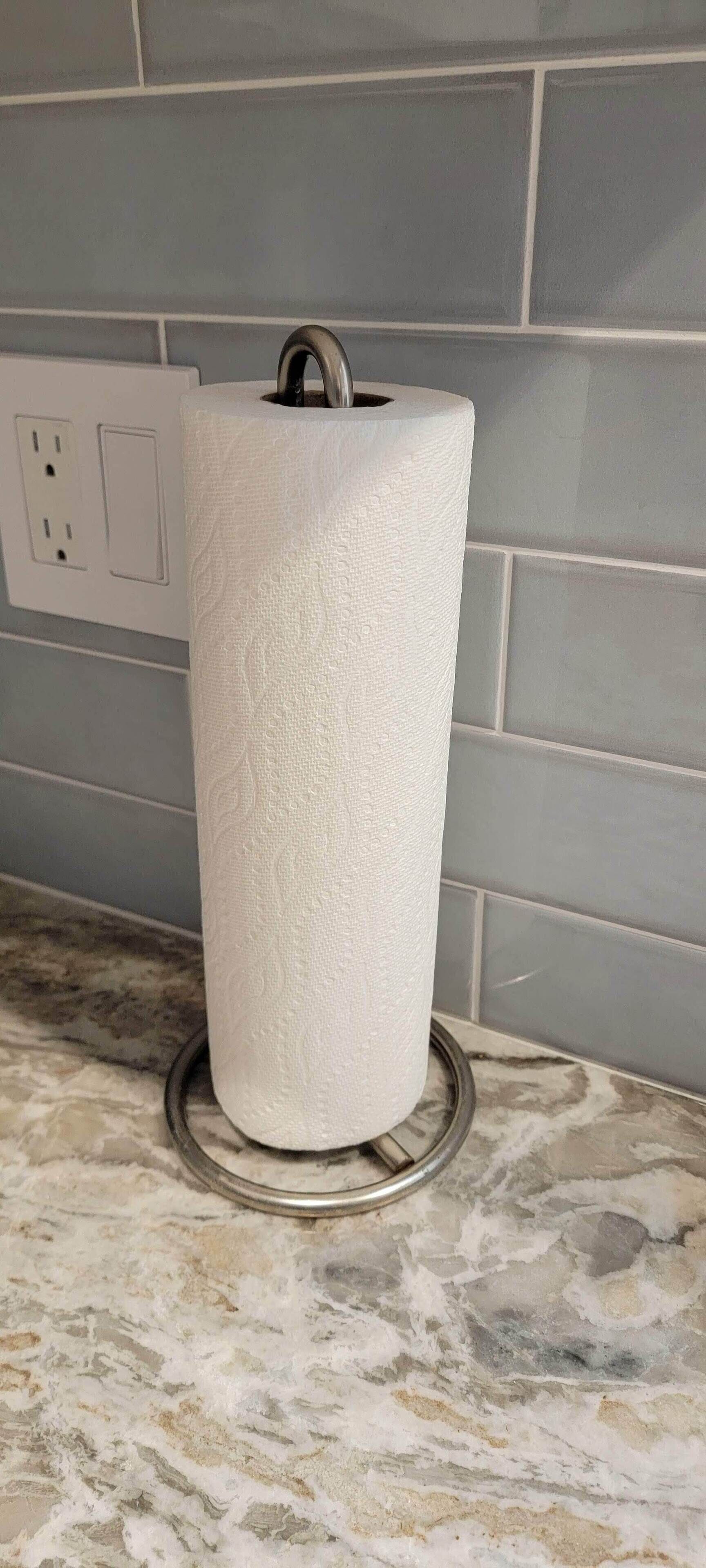 Een rol toiletpapier op een marmeren aanrecht, met een stopcontact op de achtergrond.