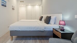 Ein modernes Schlafzimmer mit einem großen Bett, Nachttischen und einem Beistelltisch.