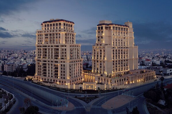A high-rise hotel with multiple floors, a central courtyard, and a view of the surrounding cityscape.