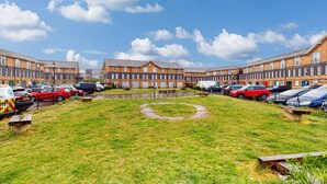 Une rangée de maisons mitoyennes avec une cour verdoyante au centre.