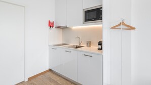 A compact kitchenette with a microwave, sink, and coffee maker. - GuestReady - Port Studio 3 (Vila Nova de Gaia)