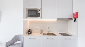 A modern kitchen with a built-in microwave, a coffee maker, and a sink. - GuestReady - Port Studio 1 (Vila Nova de Gaia)