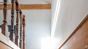 A wooden staircase with a handrail and a view of the upper floor. - GuestReady - Miragaia Stone Studio 2T (Porto)