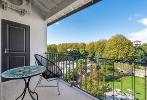 Enjoy the serene view from this balcony overlooking lush green surroundings.
