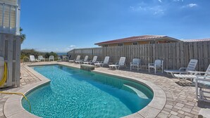Une piscine avec des chaises longues et une clôture en bois.