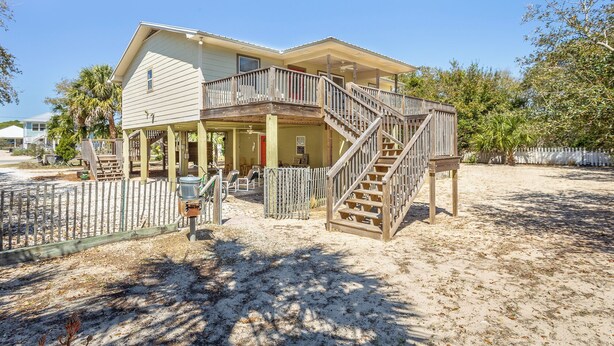 A two-story house with a balcony and a wooden staircase. - Easy Beach Access - Newly Updated! (St. George Island)