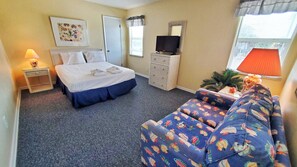Relax in this inviting space with a comfortable bed, sofa, and TV.