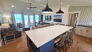 Relax in a spacious living area with a central island, comfortable seating, and a sleek kitchen.