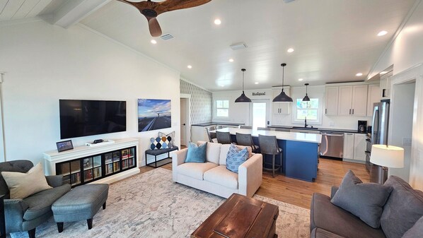Relax in a spacious living area with a large flat-screen TV and cozy fireplace, perfect for social gatherings.