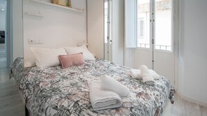 A bedroom with a bed, pillows, a mirror, and a window. - Apartment Las Lectoras de Cadiz (Cádiz)