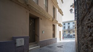 A narrow street with a building featuring a door and steps leading to a landing. - Apartment Las Lectoras de Cadiz (Cádiz)