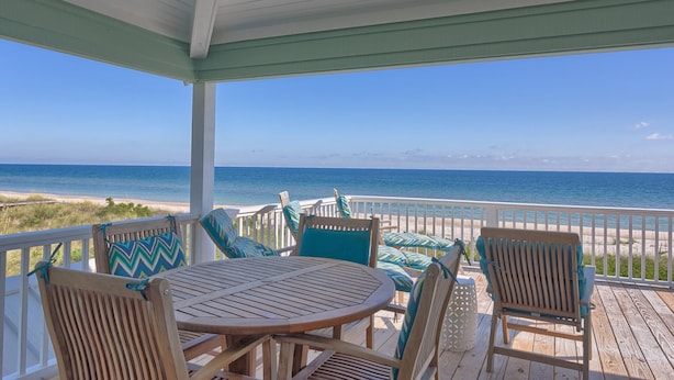 A covered outdoor seating area with a view of the ocean. - Welcome to Sea Knight! (St. George Island)