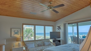 A bedroom with a bed, a television, a desk, and a window with a view of the sea. - Welcome to Sea Knight! (St. George Island)