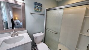 A bathroom with a sink, toilet, and glass shower enclosure. - Beachfront with large sundecks! (St. George Island)