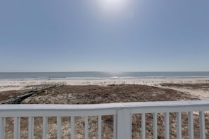 A beach view with a wooden deck and a sandy path leading to the shore. - Beachfront with large sundecks! (St. George Island)