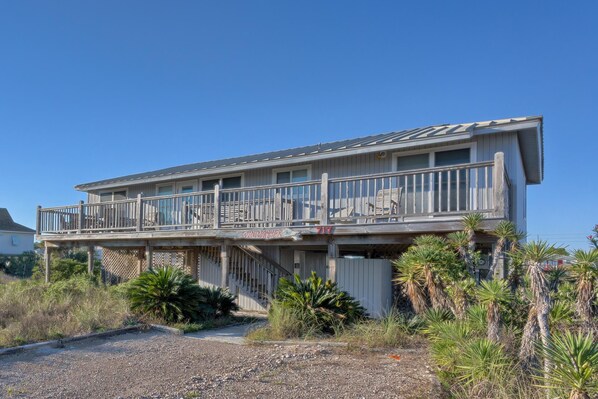 A two-story building with a balcony, wooden railings, and a sign that reads "Windjammer 717". - Windjammer: 4 BR, 2 BA House in St. George Island, Sleeps 8 (St. George Island)