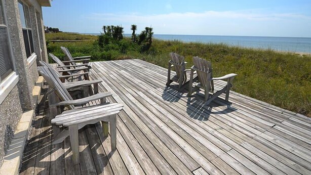 A wooden deck with Adirondack chairs and a view of the ocean. - Sandy Beach: 3  BR, 3  BA House in St. George Island, Sleeps 8 (St. George Island)