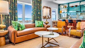 A living room with a leather sofa, round coffee table, and a view of the ocean. - BEACHFRONT! PRIVATE POOL! All new renovation. (St. George Island)