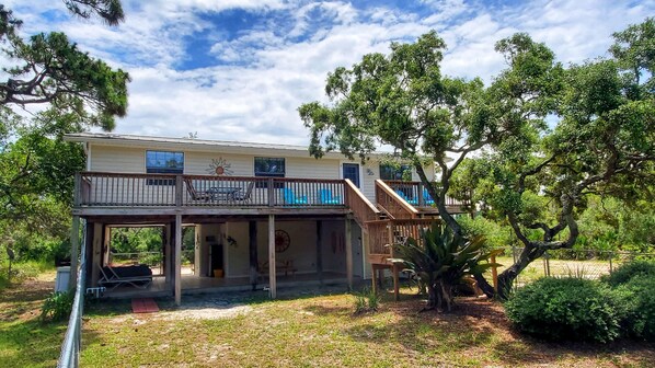 A two-story house with a balcony, a covered porch, and a swimming pool.