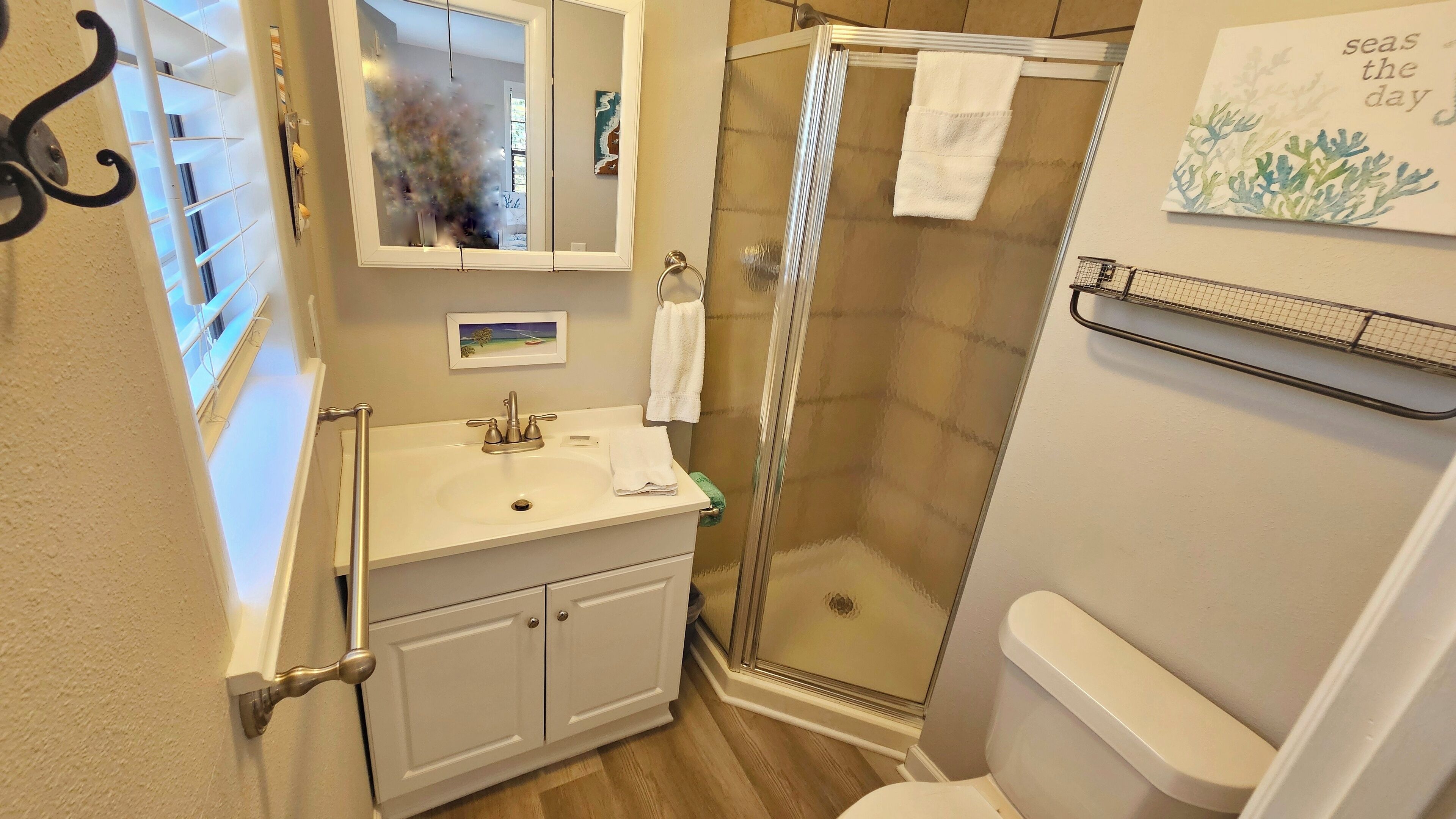 Ein Badezimmer mit Dusche, Toilette, Waschbecken und Handtuchhalter.
