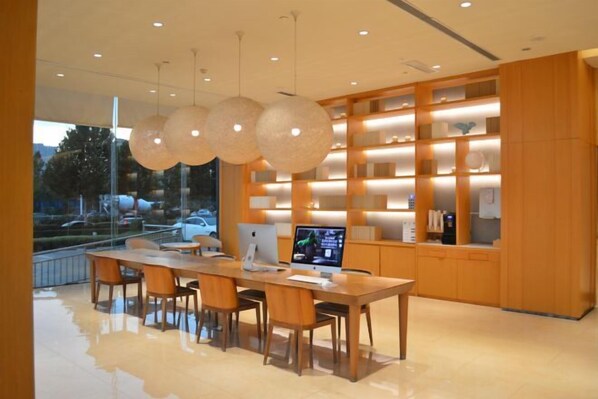 A modern kitchen with a long wooden table, built-in shelves, and pendant lighting. - JI Hotel (Linfen Zhongda Street) (Linfen)