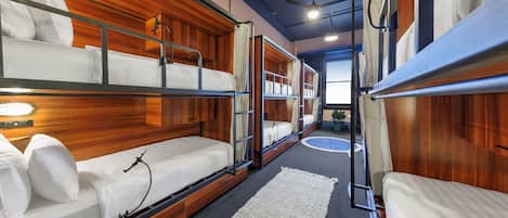 Dormitorio con literas, paneles de madera y ventilador de techo.