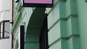 Un edificio con un letrero que dice 'Roamer' sobre un fondo rosa.