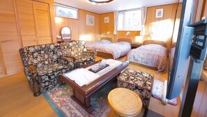 A cozy room with a floral sofa, two single beds, a wooden wardrobe, and a television. - SHIROKUMA NO YADO (Toyako)