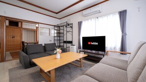 Una sala de estar con sofá, mesa de centro, televisor y estantería empotrada.