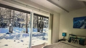 A bedroom with a large window overlooking a snowy forest. - Boreal condo 3 bed 2 bath near Boreal, Soda Springs on Boreal Lake & near Donner (Truckee)