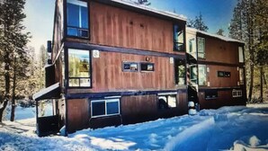 A multi-story building with a wooden facade, large windows, and a balcony. - Boreal condo 3 bed 2 bath near Boreal, Soda Springs on Boreal Lake & near Donner (Truckee)