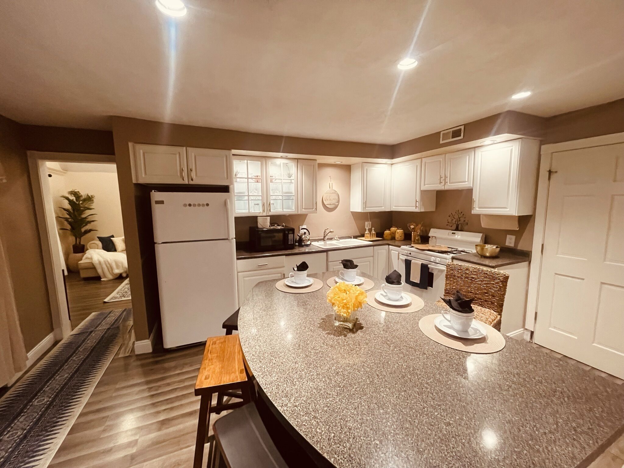 A modern kitchen with white cabinets, a granite countertop, and a built-in oven.