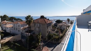 A balcony with a view of a marina and residential buildings. - 1-Br Apartment, Sea View Terrace & Parking (Cannes)