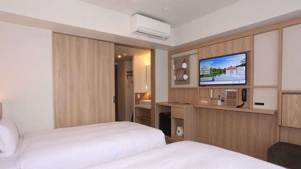 A hotel room with two beds, a TV, a minibar, and a wooden wardrobe. - Sapporo Washington Hotel Plaza (Sapporo)