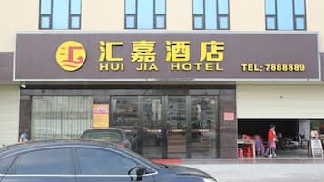 Un hotel con un letrero que muestra el nombre 'HUI JIA HOTEL' y un número de teléfono.
