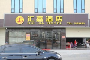 Un hotel con un letrero que muestra el nombre 'HUI JIA HOTEL' y un número de teléfono.