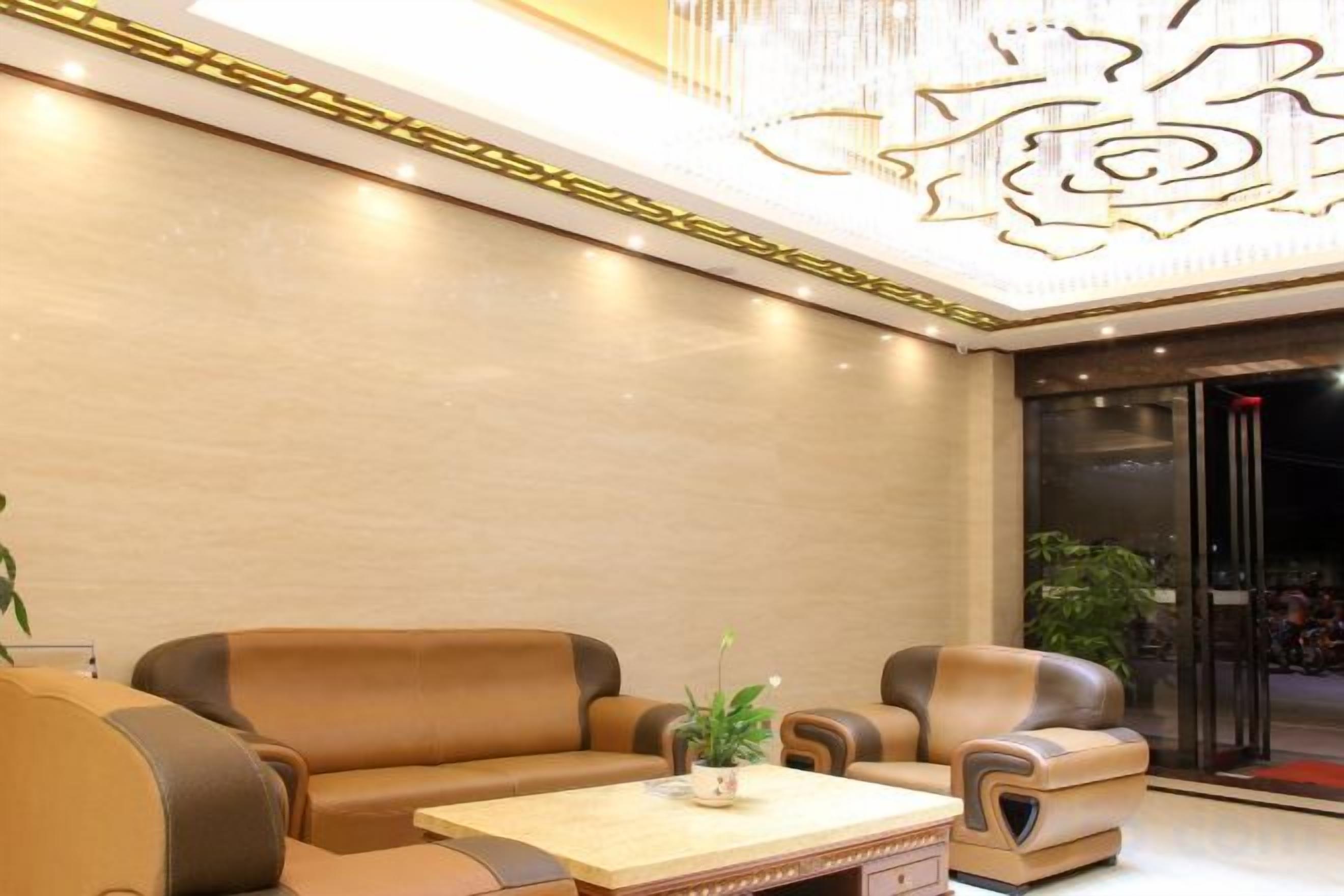 A lobby with leather sofas, a coffee table, and a decorative ceiling.