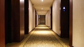 Een hotelgang met tapijttegels en deuren aan beide kanten.