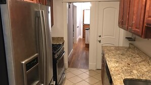 A kitchen with stainless steel appliances, wooden cabinets, and a tiled floor. - Brookland Quiet Living (Washington)