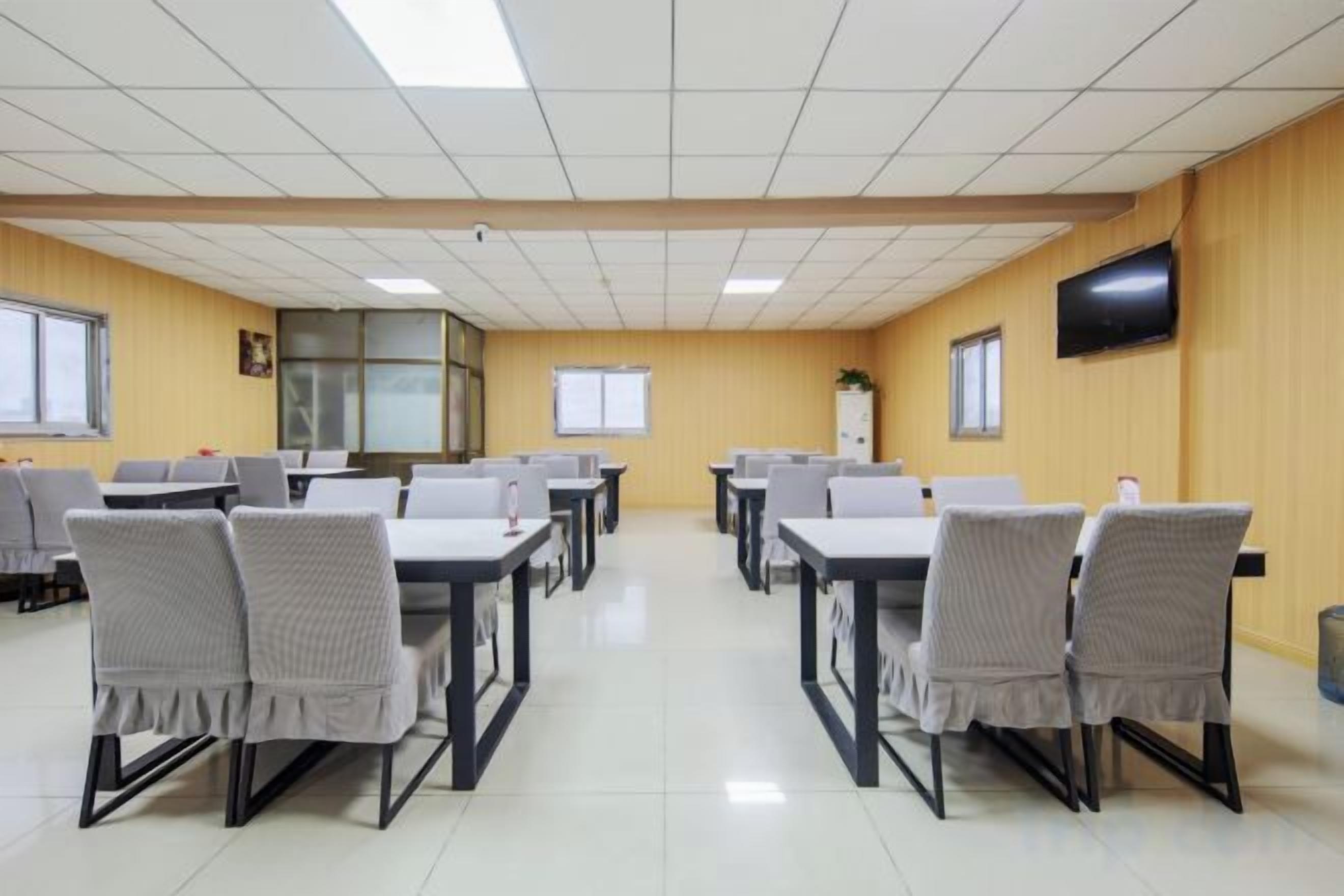 Un salón de conferencias con mesas y sillas dispuestas para reuniones.