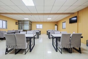 Une salle de conférence équipée de tables et de chaises disposées pour les réunions.