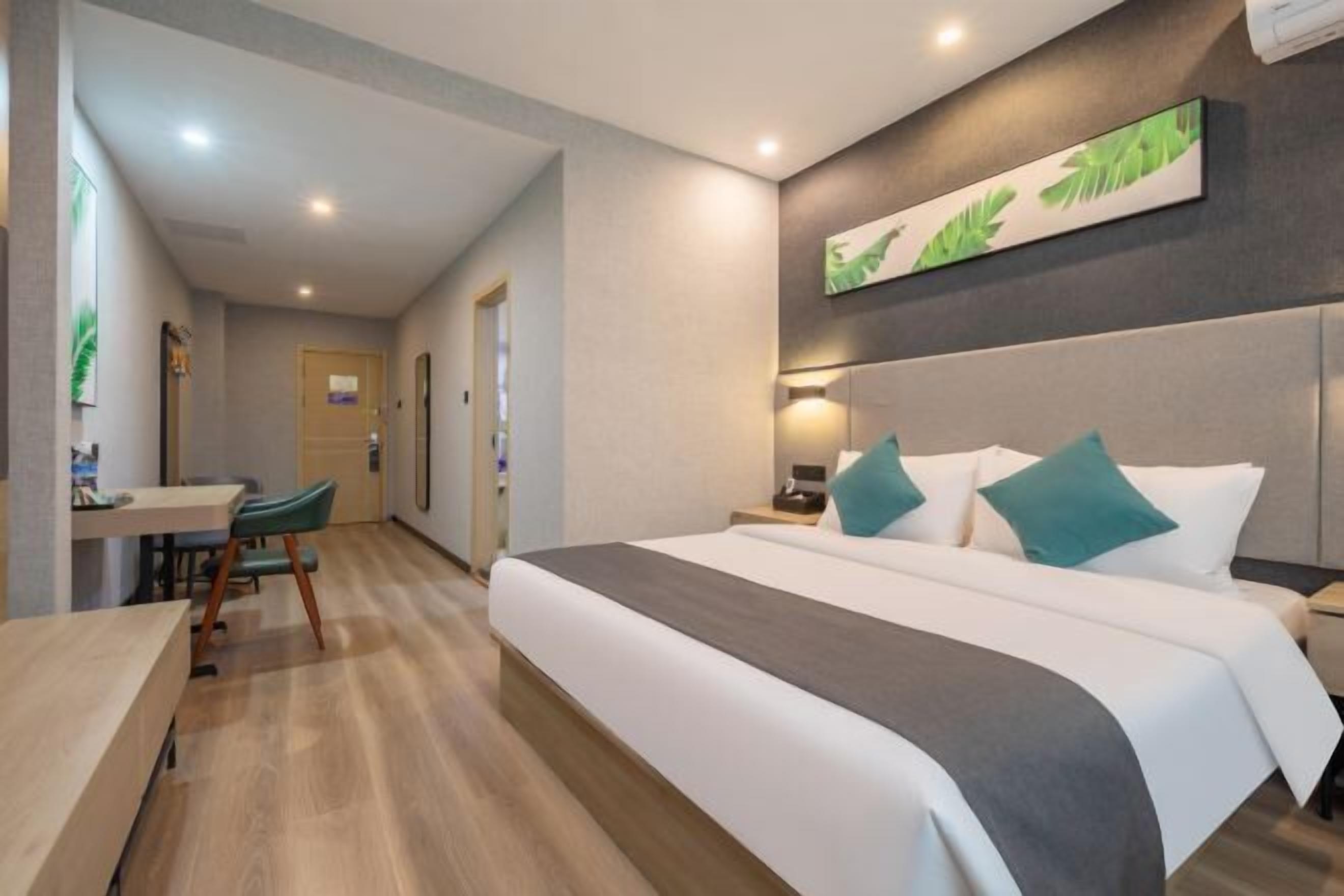 Una habitación de hotel con una cama grande, un escritorio y una silla.
