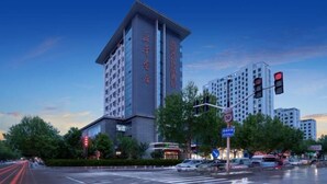 Un hôtel moderne doté d’une tour imposante, de nombreux étages et d’une entrée bien visible.