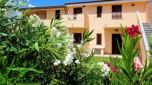 A two-story building with balconies, a flat roof, and a clear blue sky. - Lovely apartment for 4 people with A/C, TV, terrace and pets allowed (Valledoria)