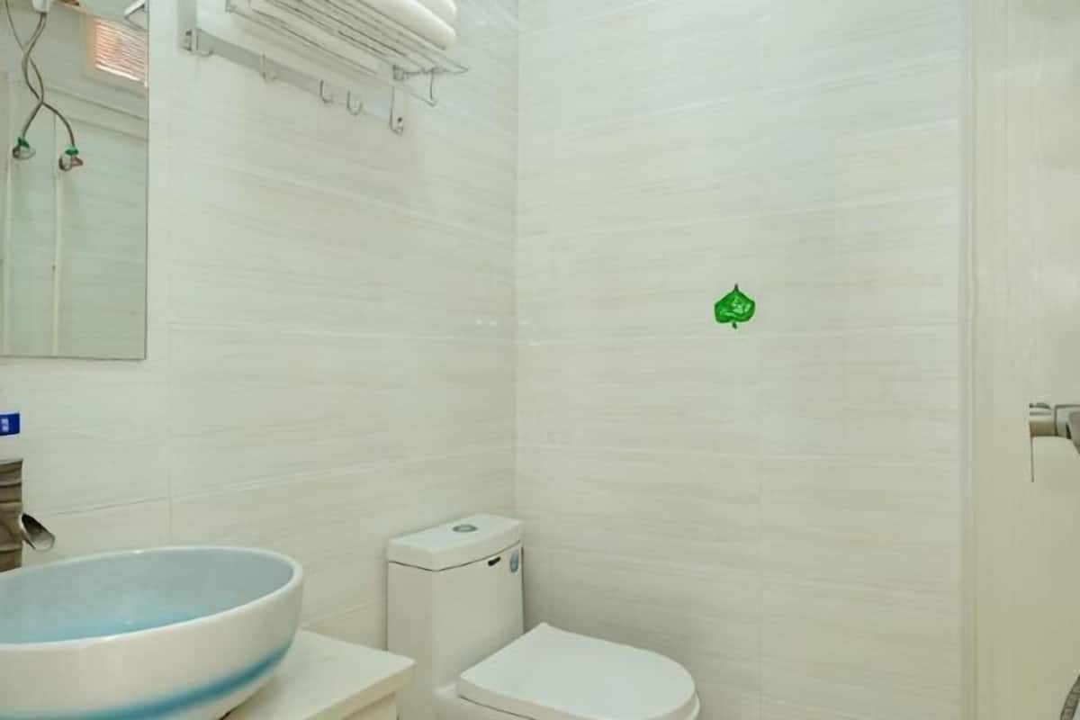 A bathroom with a toilet, sink, and mirror.