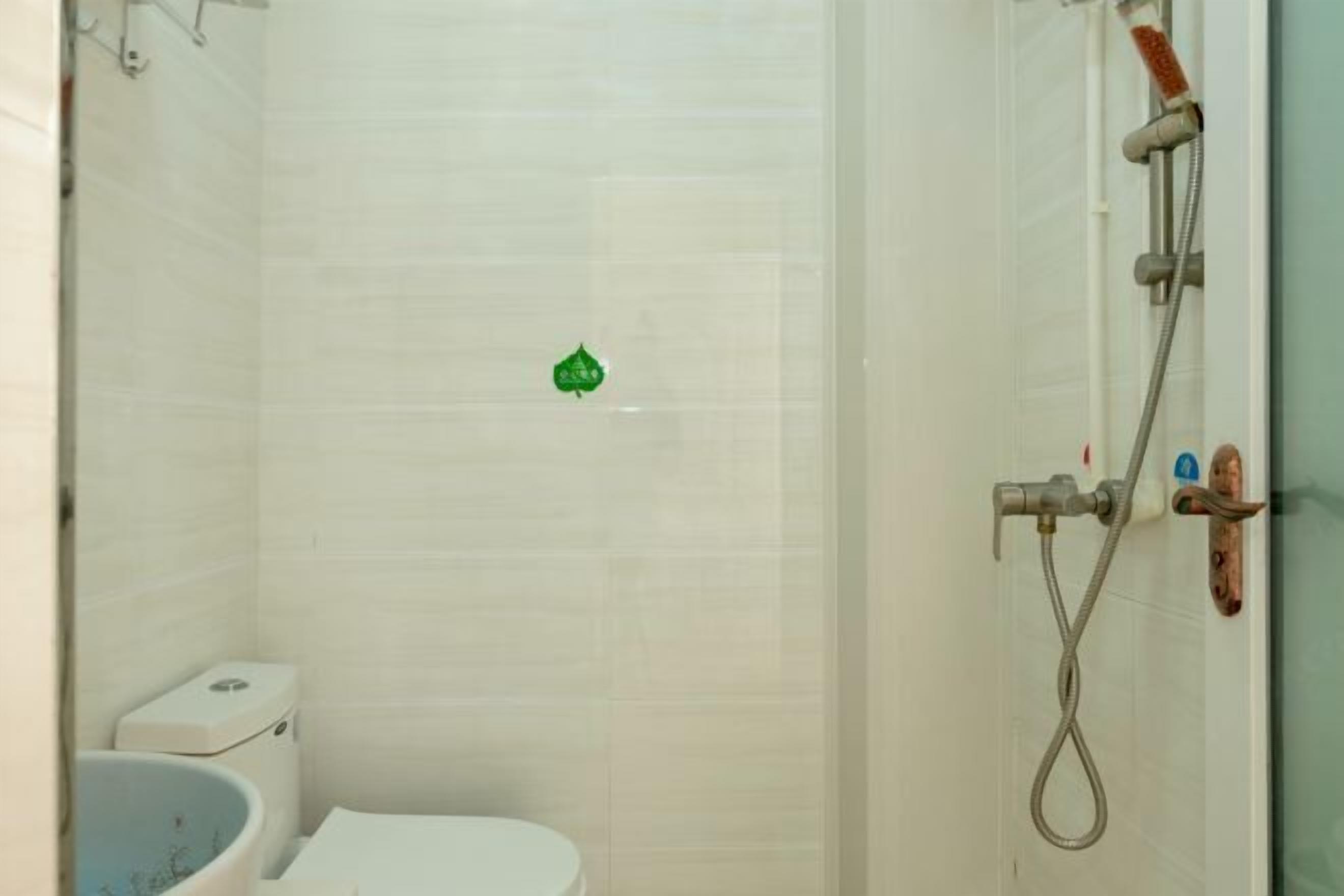 A small, enclosed shower area with a toilet and a showerhead.