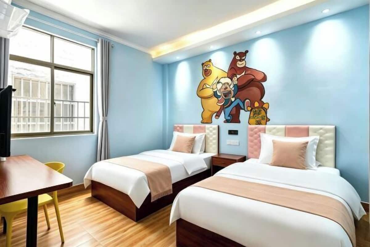A hotel room with two beds, a desk, a chair, and a large window.