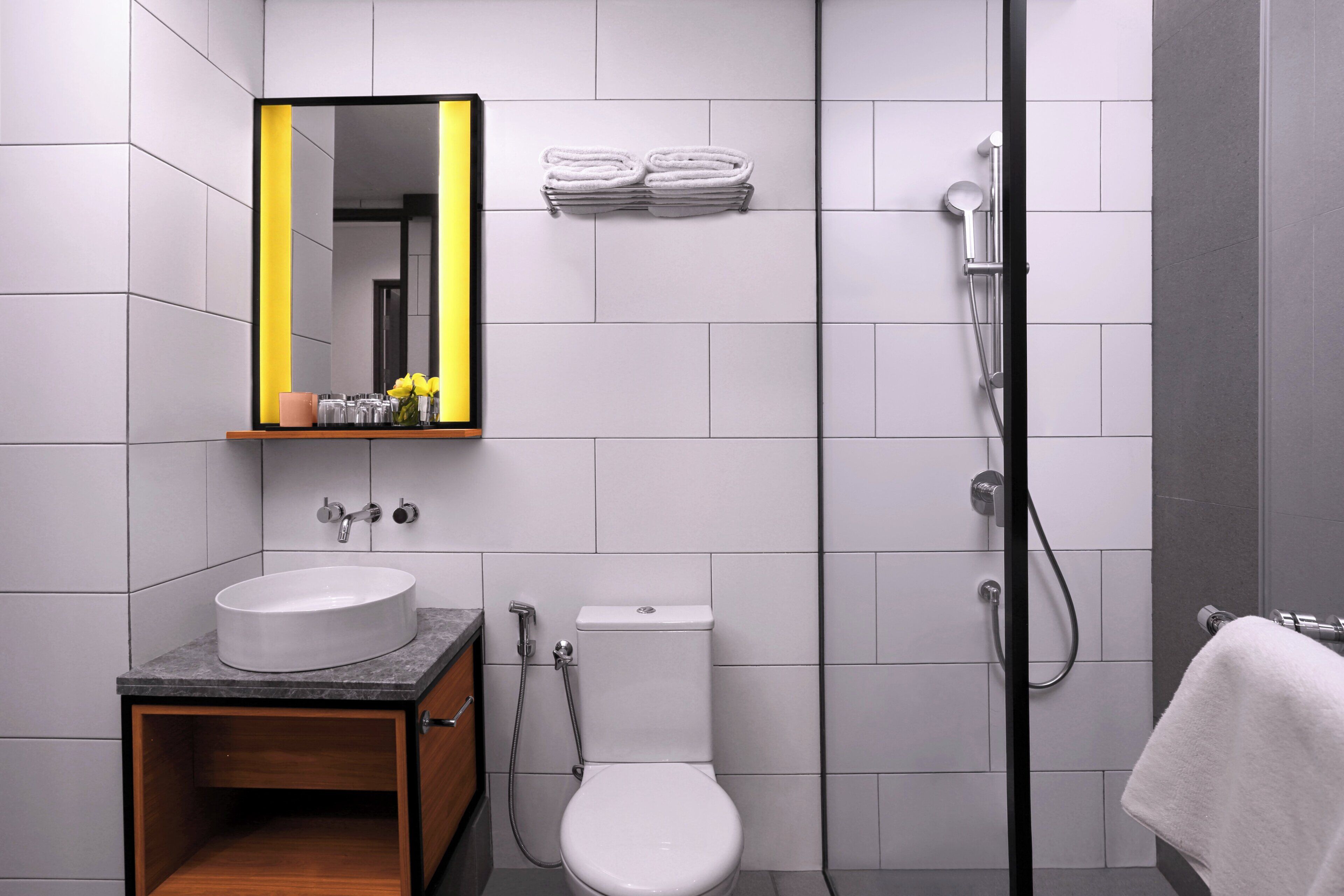 Un baño moderno con lavamanos, inodoro y ducha.