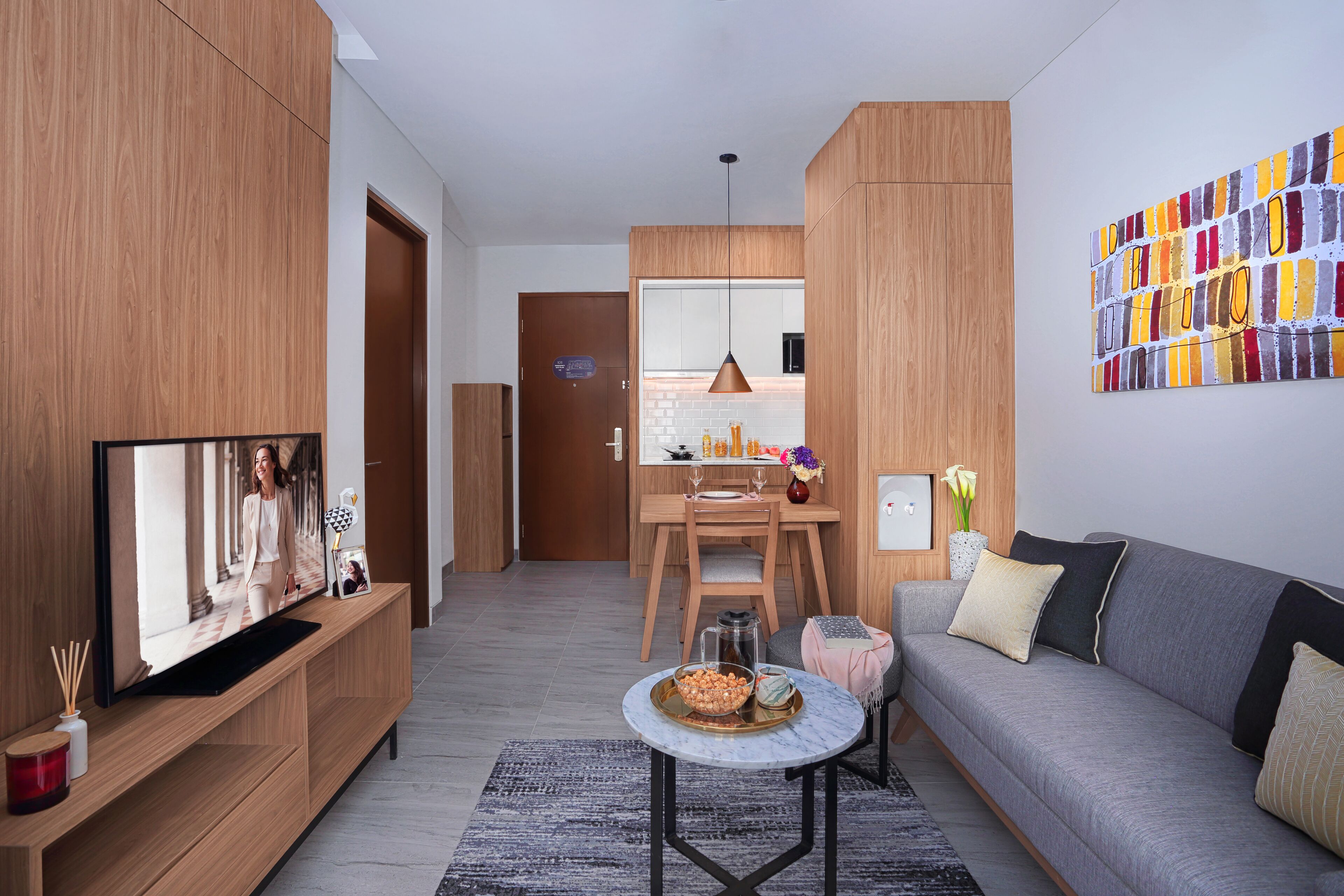 Ein modernes Wohnzimmer mit Fernseher, Sofa, Couchtisch und Holzschränken.